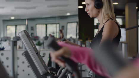 Sporty-woman-listening-to-music-and-exercising-at-gym