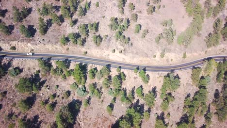 un camino sinuoso en el medio oeste de estados unidos con un auto conduciendo junto a él