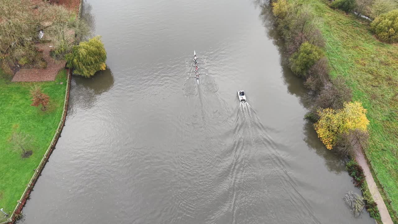Overhead birds eye drone aerial view four man sculls rowing on Thames Marlow UK
