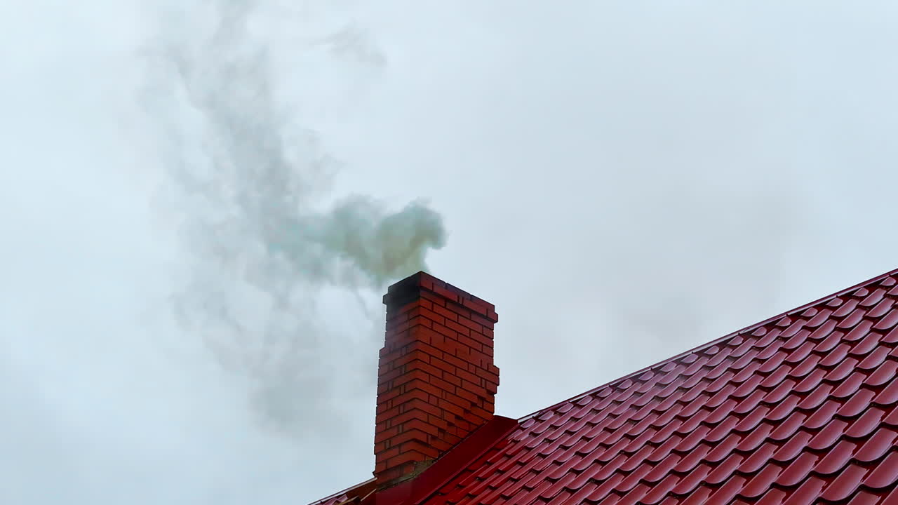 Smoke rises from private home chimney during heating season