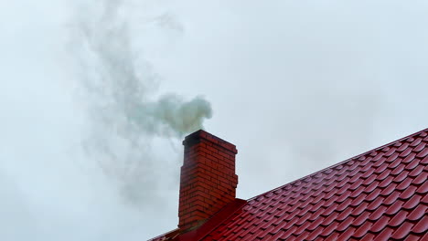 smoke rises from private home chimney during heating season