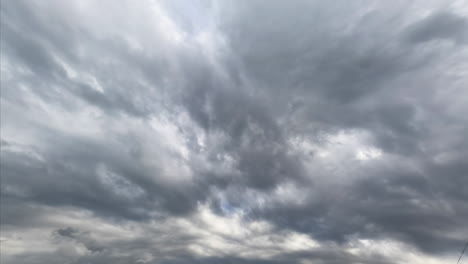grey gloomy cloudscape totally covering the horizon. rainy clouds gathering in the sky. low angle view. timelapse.