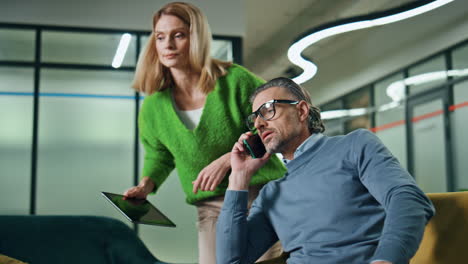 two colleagues working together office. woman consulting with calling phone man