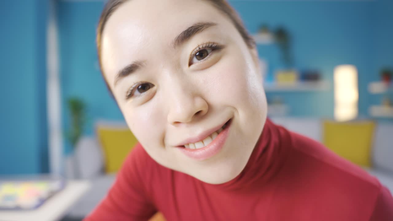 예쁜 아시아 여성이 카메라를 향해 손을 흔들고 있습니다.