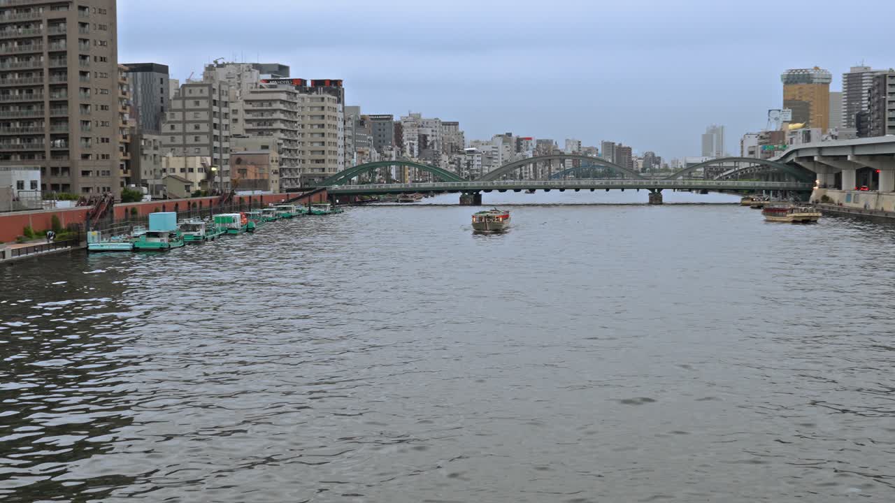 The distinctive blue illumination of Komagata Bridge gracefully spans the Sumida River at twilight, a striking landmark in the Tokyo cityscape.