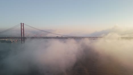 the 25 de abril bridge suspension bridge on a misty sunrise in lisbon, portugal
