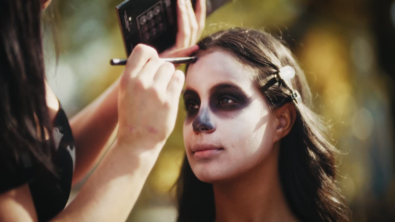 Applying Dia de los Muertos Face Paint