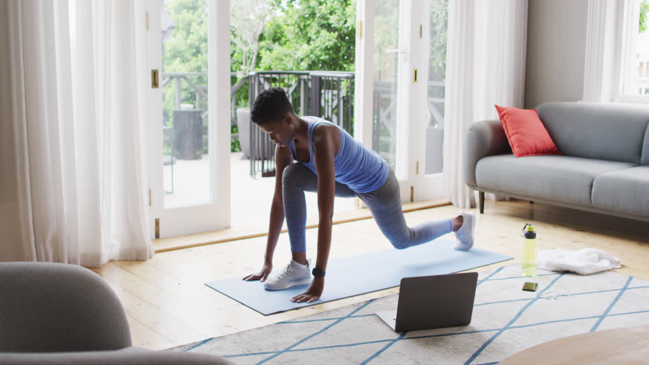 African american woman performing stretching exercise at home