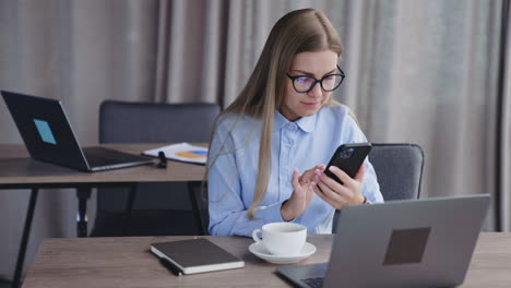 mujer de negocios que usa un teléfono inteligente en una oficina moderna