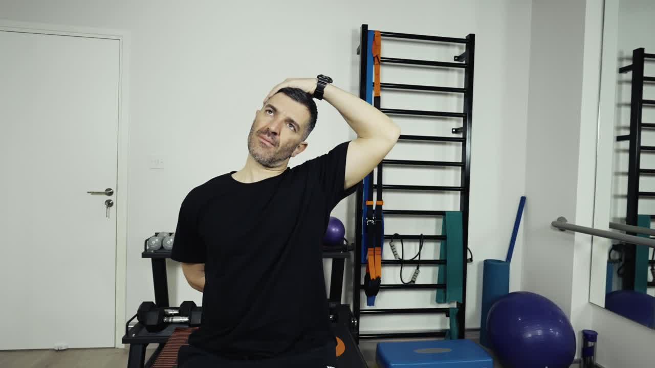 Um homem se exercitando e alongando em uma pequena academia em casa