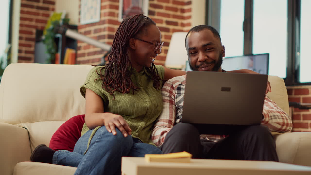 African american couple watching video on laptop together