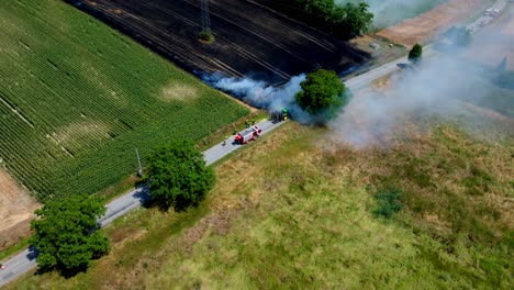 bomberos atendiendo un incendio en un campo agrícola - disparo aéreo de un dron
