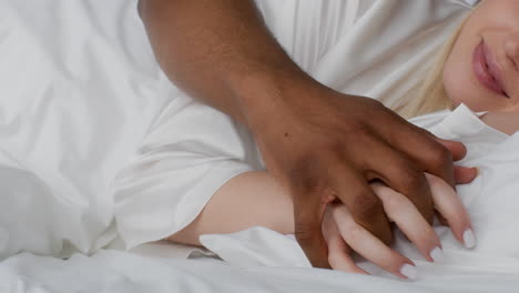 couple holding hands in bed