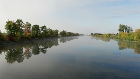 low altitude flight over smooth flat surface of river in early morning light