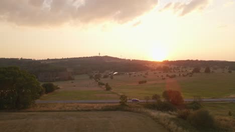 Low-Aerial-Dolly-With-A-Sunsetting-Behind-A-Hill-With-Solar-Panels-Coming-Into-Frame