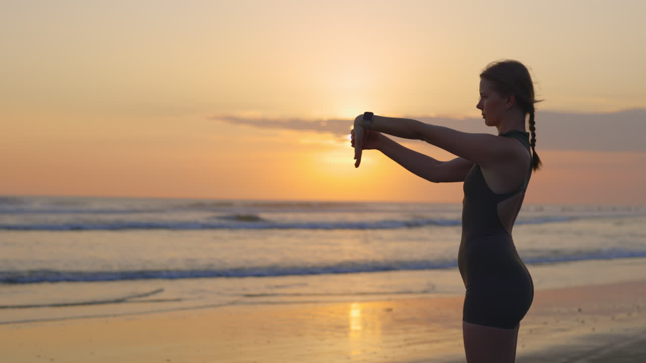 Donna che fa stretching in spiaggia all'alba