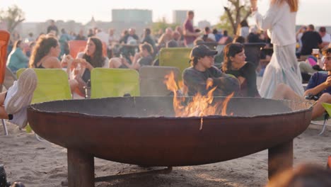 friends enjoying a bonfire on the beach at sunset
