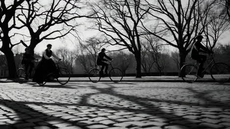 a person riding a bicycle on a cobblestone street in black and white