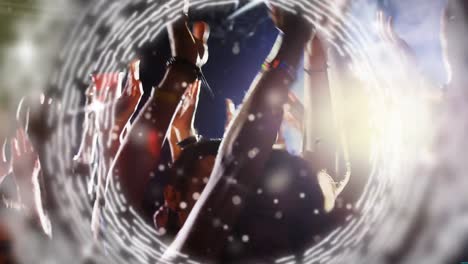 glowing circle moving against people dancing in a concert