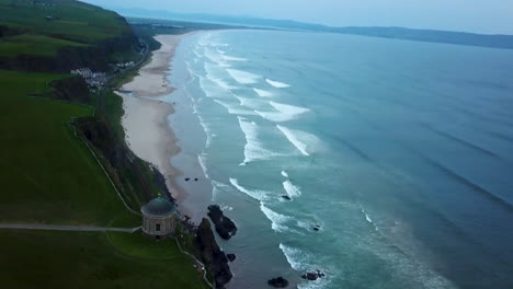 Cinematic-drone-shot-of-Mussenden-Temple-located-on-cliffs-near-Castlerock-in-County-Londonderry,-in-Northern-Ireland