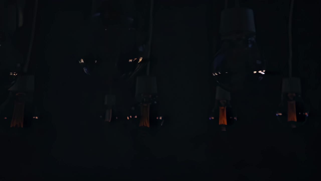 Close-up video of glowing vintage Edison bulbs against a dark background, capturing the warm