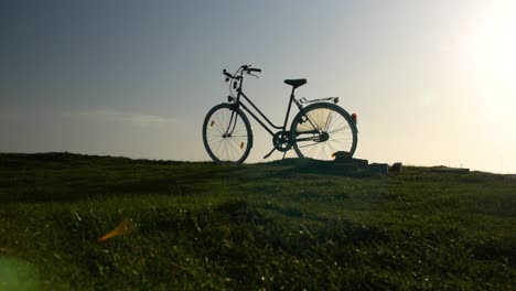 Una-Bicicleta-Está-Parada-En-Un-Campo,-El-Cielo-Azul-Está-En-El-Fondo