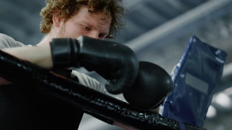 Depression-sportsman-standing-on-ring.-Fighter-leaning-on-ropes-in-sport-club