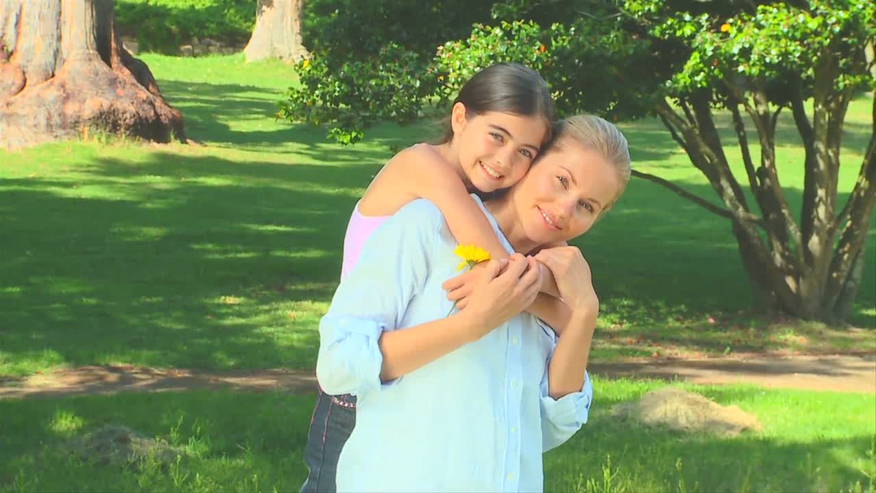 어린 소녀가 어머니를 안아주고 있습니다.