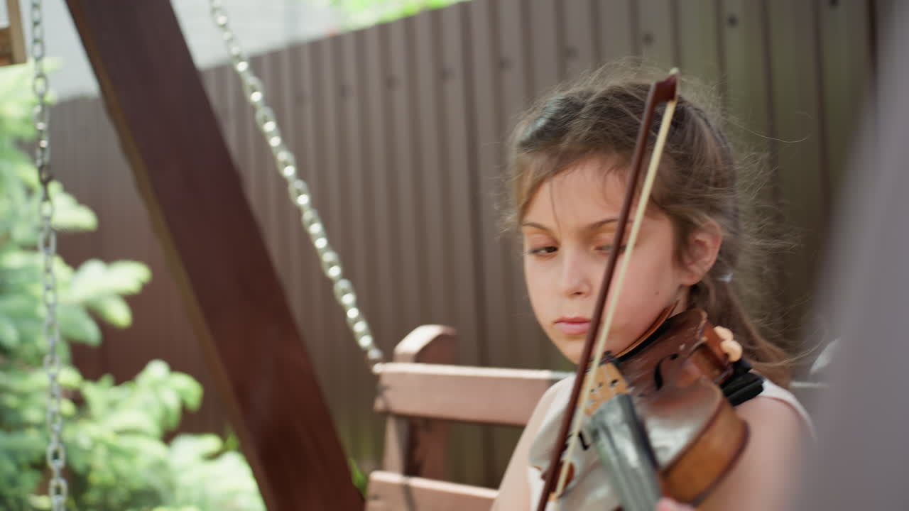 Young Girl Practicing, Caucasian Girl Diligently Refining Her Skills In Calm Garden Environment, Serene Garden Setting Where Young Woman Carefully Improves Her Bowing Technique With Concentration