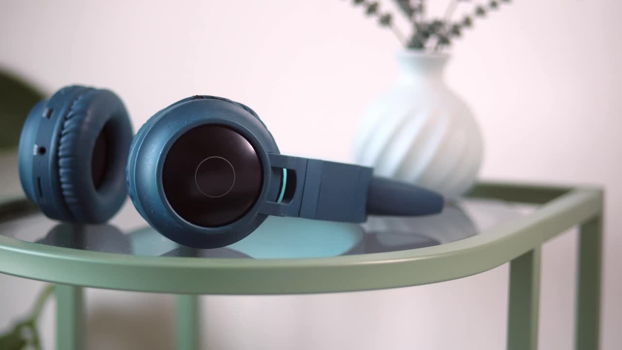Headphone Nirkabel Biru Tergeletak di Atas Meja Samping Modern