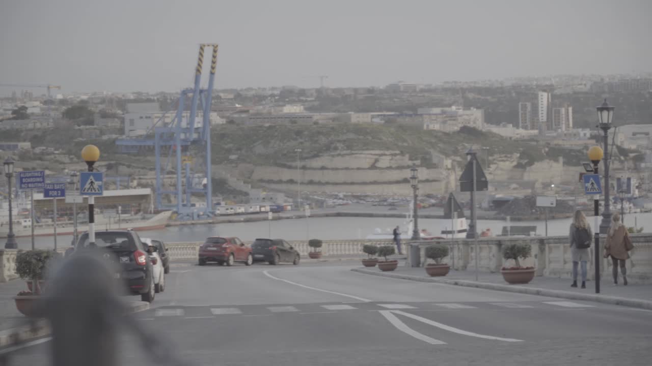 Pan of a distant view of a road and a port