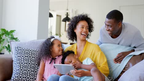 Vista-Frontal-De-Una-Familia-Negra-Usando-Una-Tableta-Digital-En-La-Sala-De-Estar-De-Casa-4k