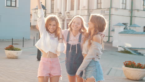 three happy friends laughing in the city