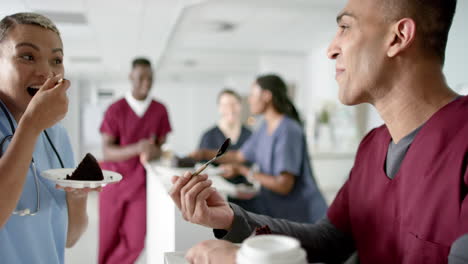 diversos médicos masculinos y femeninos comiendo pastel de cumpleaños en la recepción del hospital, en cámara lenta