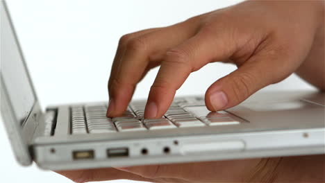 masculine hand typing on laptop keyboard