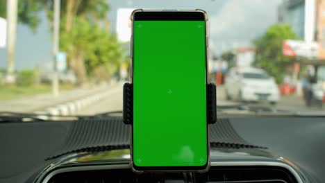teléfono como dispositivo de navegación, pantalla verde en blanco modelo de teléfono inteligente en el tablero de instrumentos del coche.