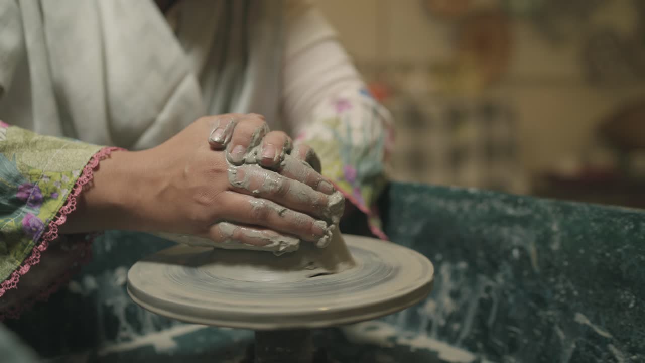 crafting clay with both hands during pottery shaping process