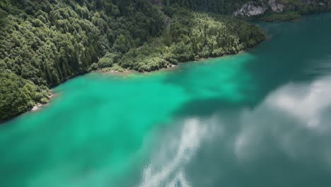 Luftaufnahme-Der-Wunderschönen-Wolkenreflexion-Im-Blau-türkisfarbenen-Wasser-Des-Klontalersees