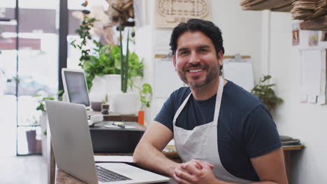 Retrato-De-Un-Asistente-De-Ventas-Masculino-Trabajando-En-Una-Computadora-Portátil-Detrás-Del-Mostrador-De-Ventas-De-Una-Floristería