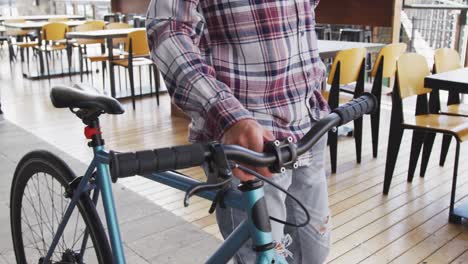 mixed race man walking with bicycle in street