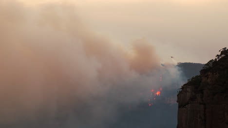 alejarse de un helicóptero que arroja agua sobre un incendio forestal en australia