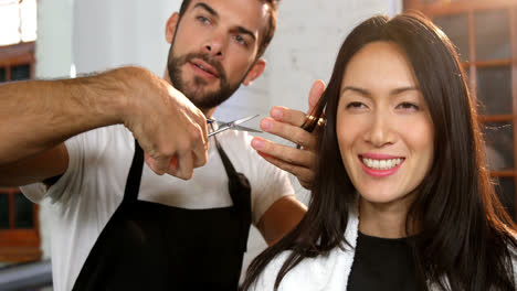 woman getting his hair trimmed with scissor