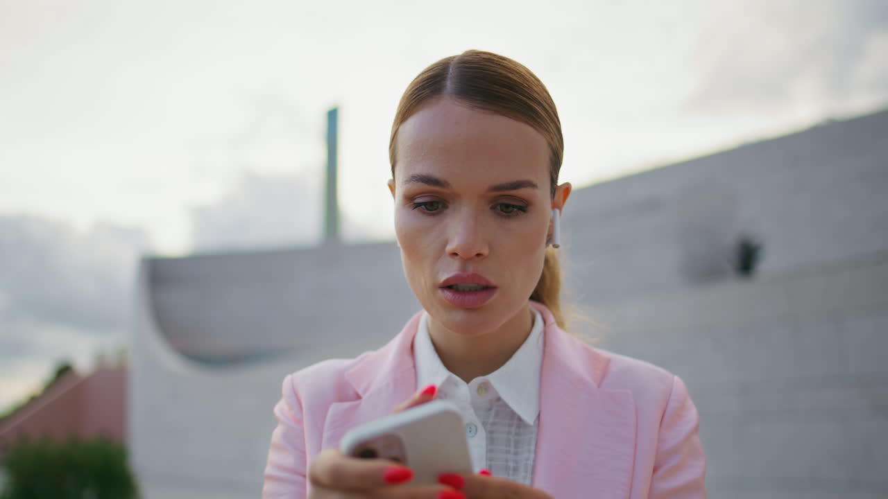 señora auriculares mirando pantalla de teléfono inteligente haciendo pedidos en línea al aire libre en la calle.