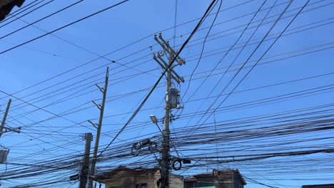 dense network of tangled electrical wires and transformers fill the sky above a city street—perfect for infrastructure, energy, and technology themes