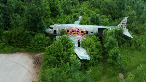 Wide-drone-pan-shot-over-viewing-historic-plane-at-abandoned-air-base