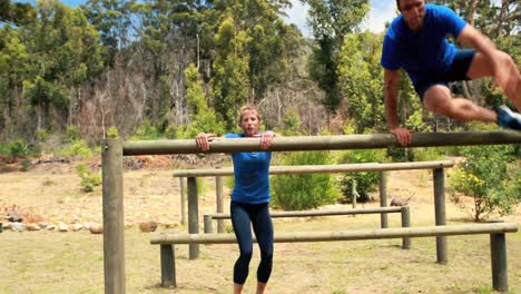 Fit-man-and-woman-climb-a-hurdles-during-obstacle-course