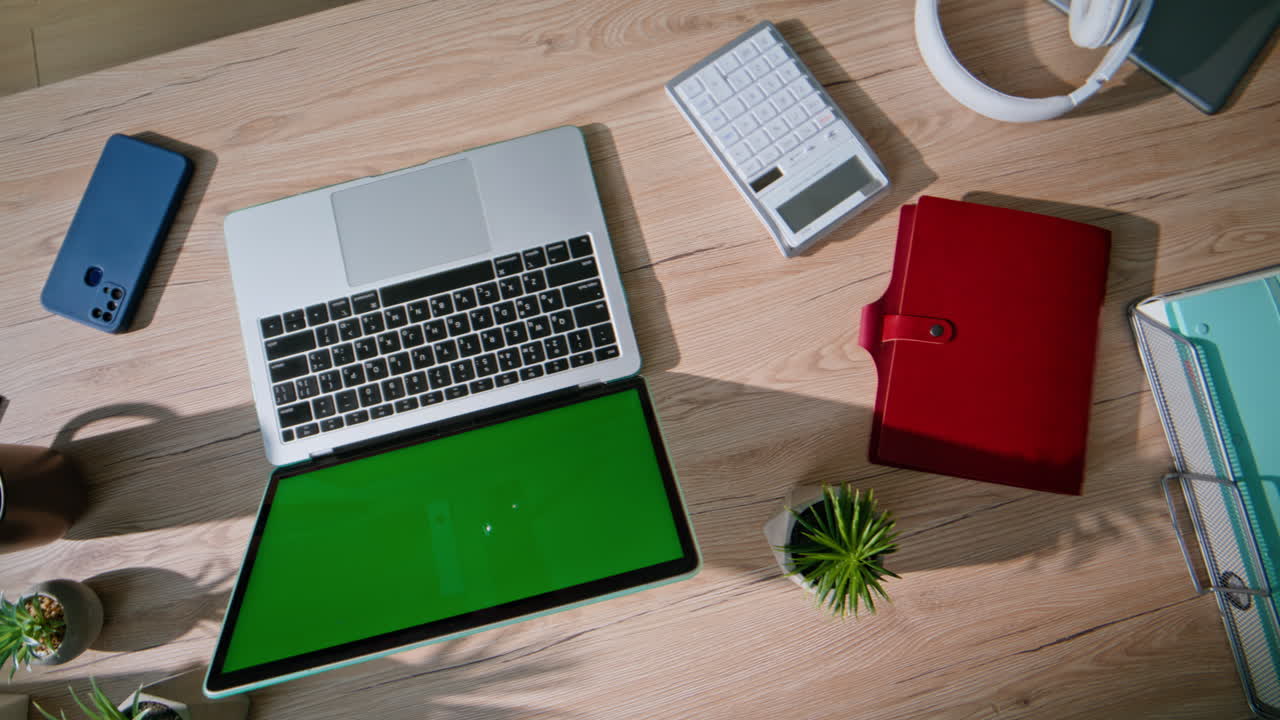 Top technological office desk with green screen laptop closeup. Empty office