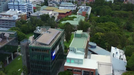 cinematic aerial birds eye view drone flyover queensland university of technology research institution qut gardens point campus, tilt up reveals south bank parklands across the river, brisbane city