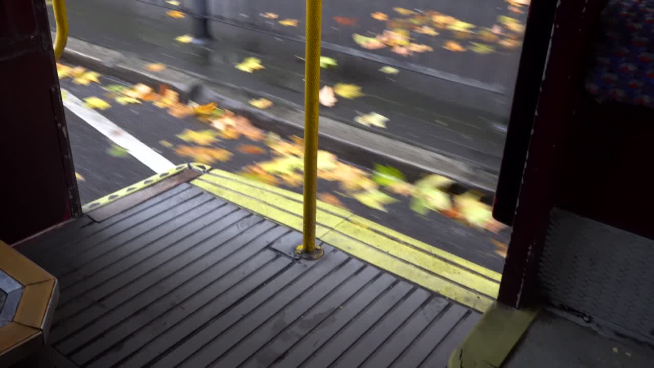 View of street passing by from onboard a London red bus.