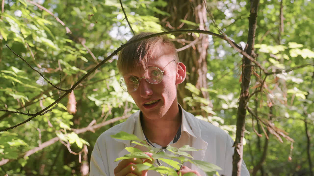 Portrait view of scientific researcher in white coat observing leaves in forest using microscope, focusing on ecological details and scientific study under natural sunlight within woodland